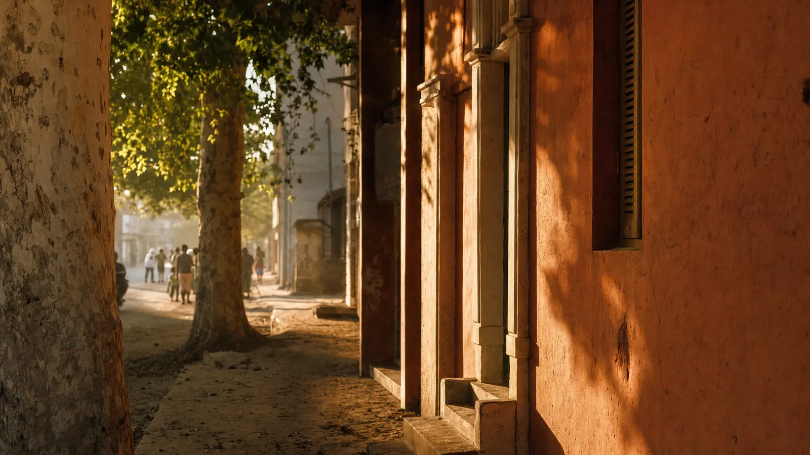 Une rue d'Abidjan à l'heure dorée, murs ocres et lumière rasante.